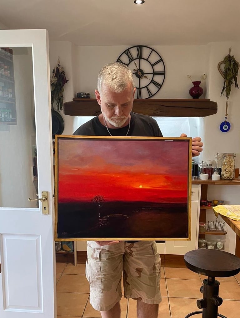 The Artist Chris Gill, holding his painting of Wallabrook Clapper Bridge at Sunset