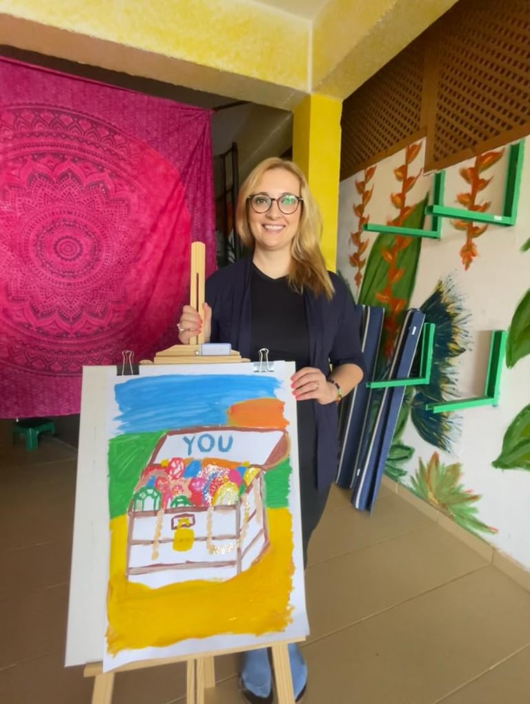 a woman holding a painting of a house