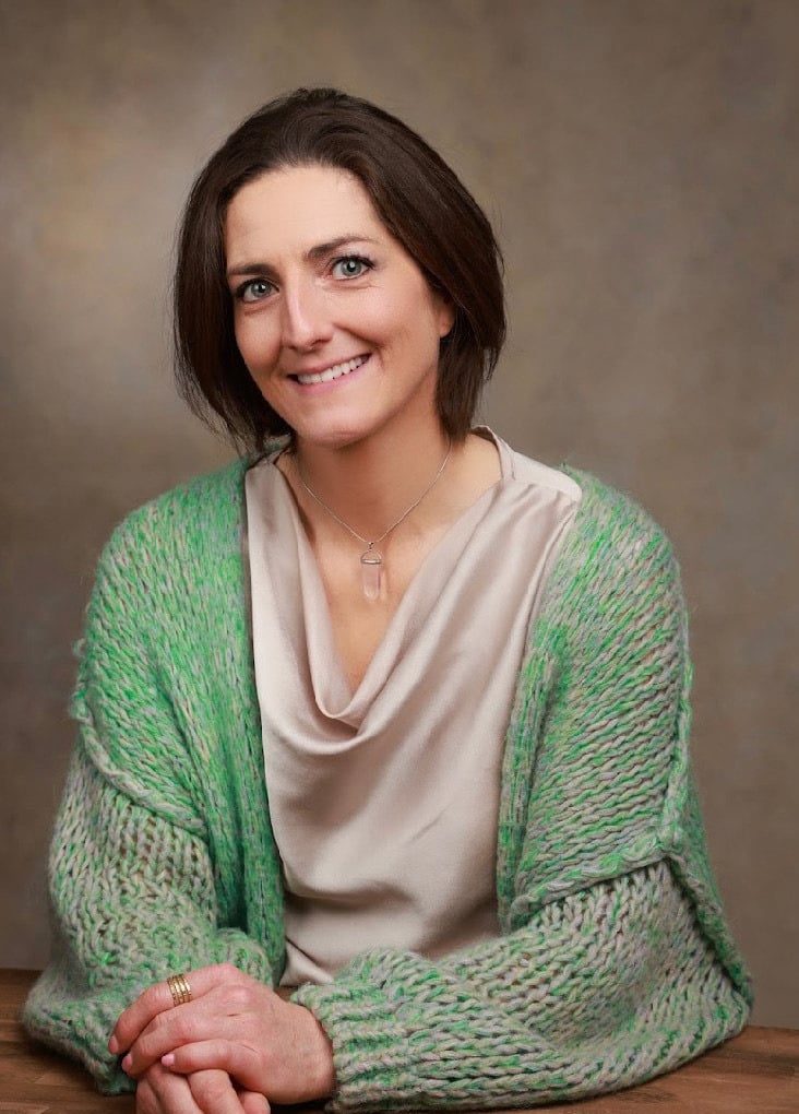 Seated  portrait Louise Mac Sweeney Funeral celebrant Green cardigan