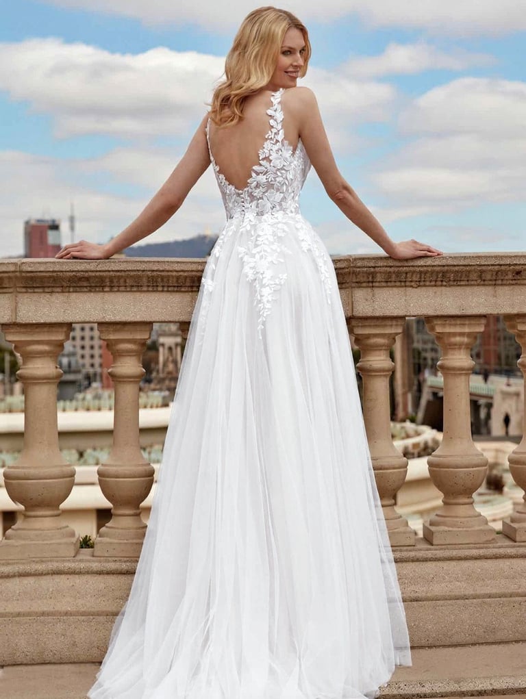 a woman in a white dress standing on a balcony
