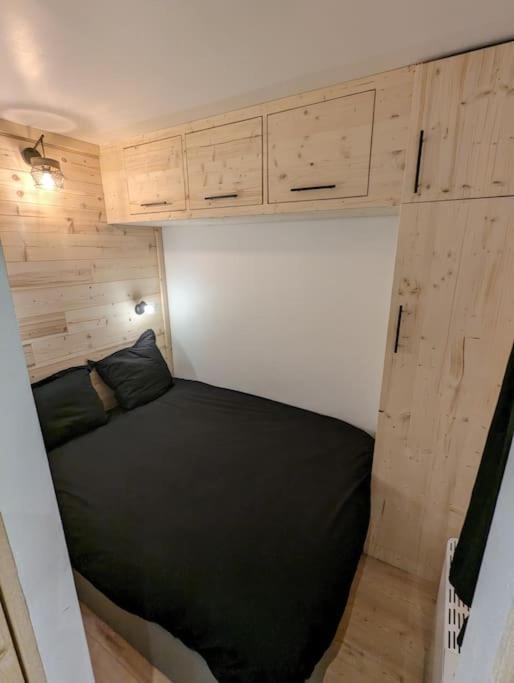 Comfortable double bedroom with alpine wood design and integrated storage in a cozy mountain apartment in Val Thorens.