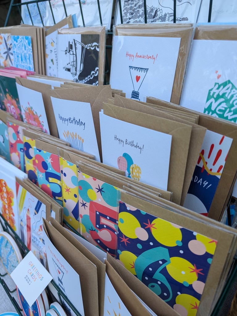 A collection of Inky Acorn Designs' colourful greetings cards on display