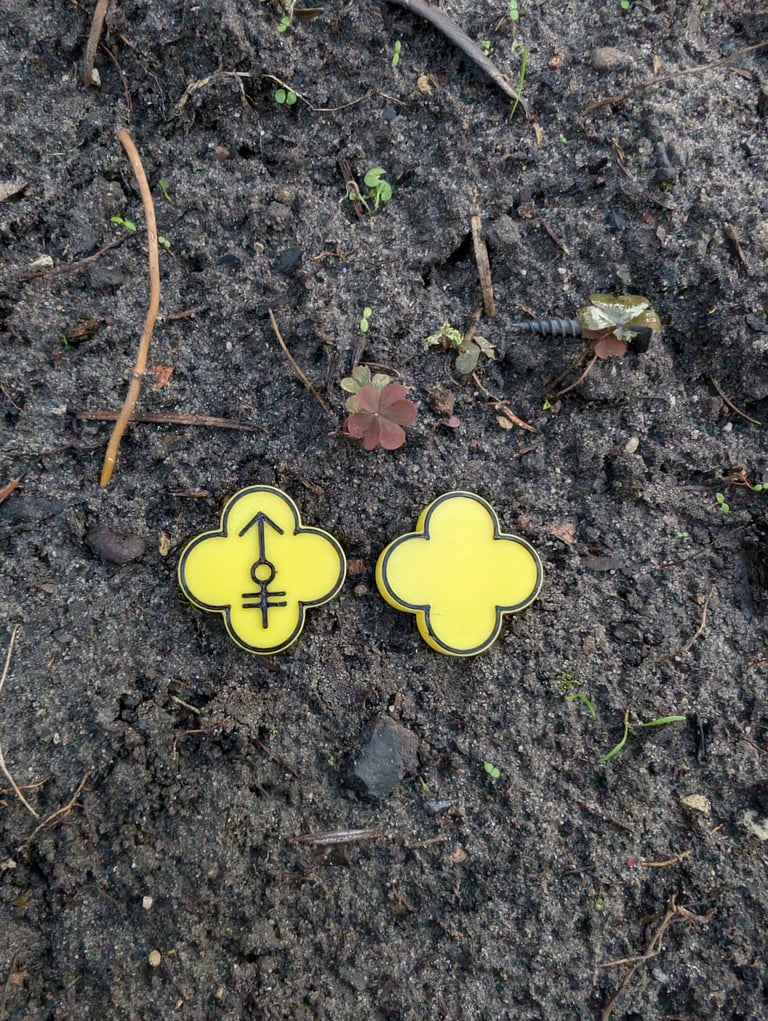 a pair of yellow and black flower shaped numbers on a dirt ground