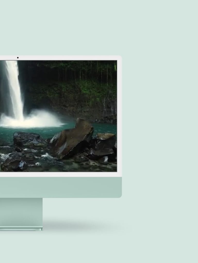 a desktop computer monitor with a waterfall in the background