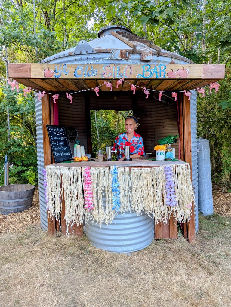 A woman serves drinks at a tropical-themed tiki bar built inside a repurposed metal grain silo.