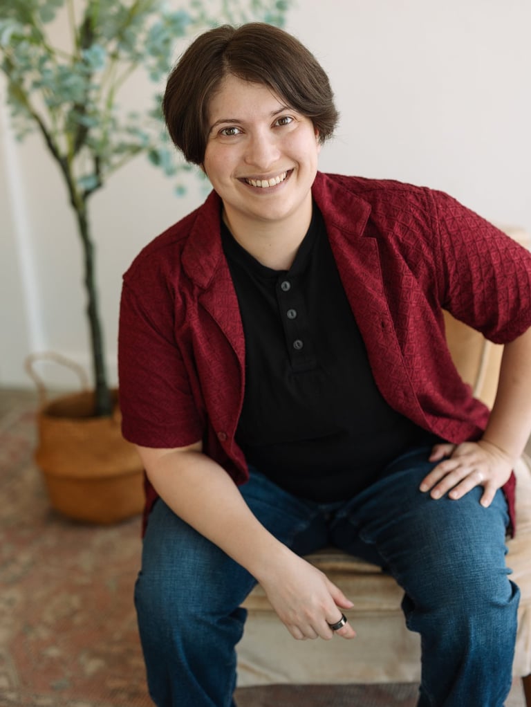 Photo of Rashad McAllister wearing a black and a red shirt and smiling warmly at the viewer