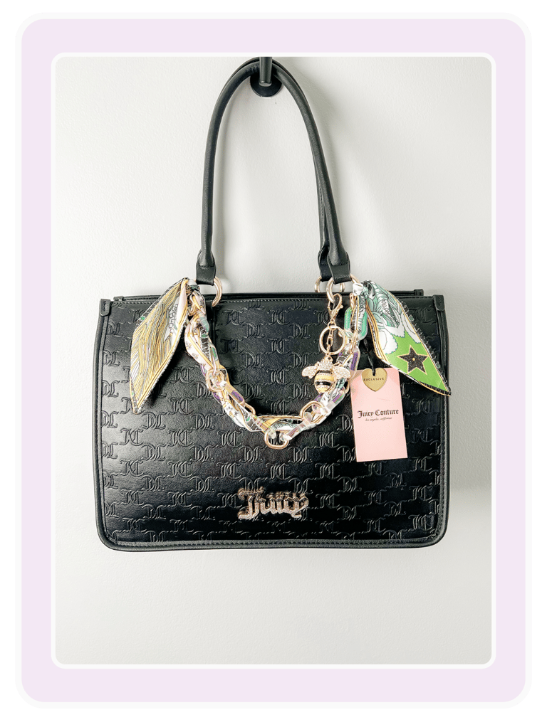 Black Juicy Couture monogram tote bag with gold chain strap, silk scarves, and heart-shaped logo charms.