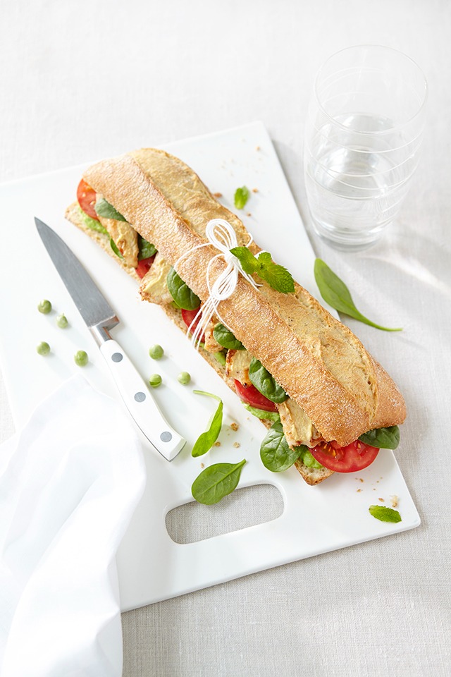 a sandwich sandwich on a cutting board with a knife and knife