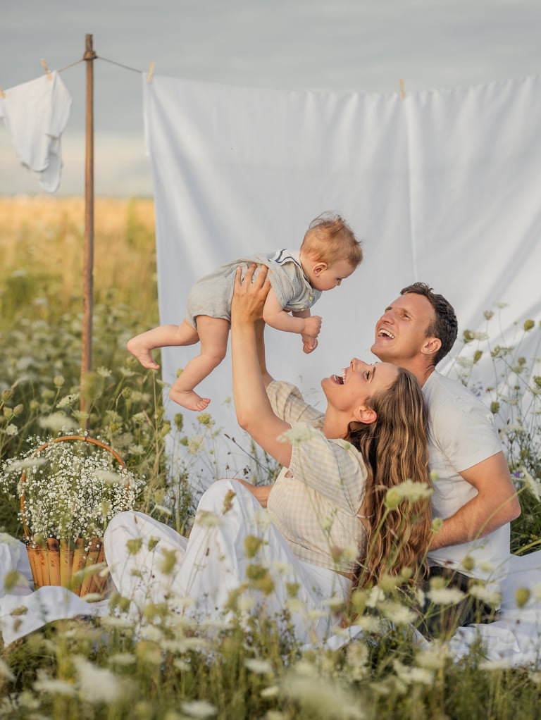 a man and woman sitting on a blanket in a field