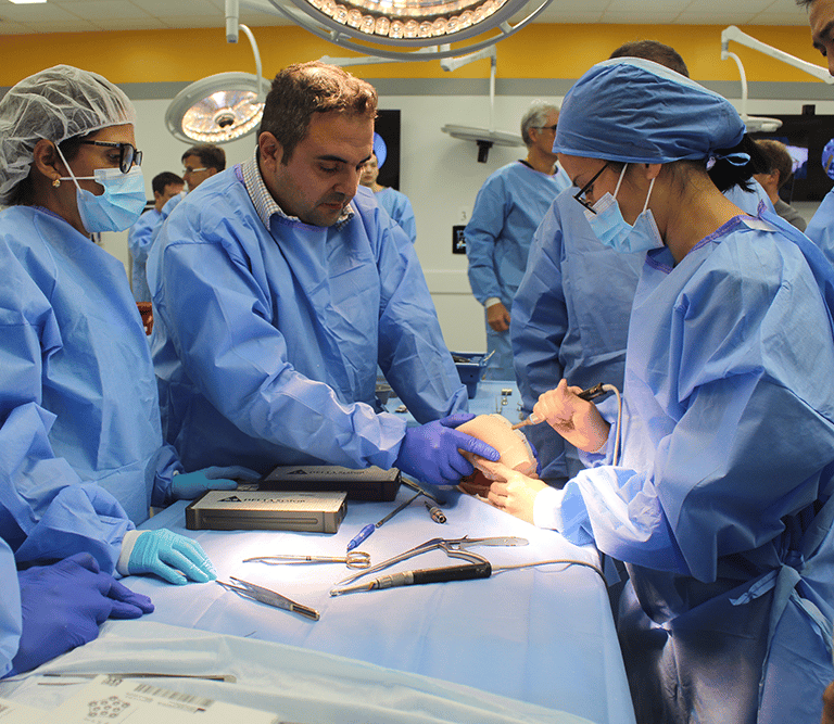 A surgeon teaches students surgery technique