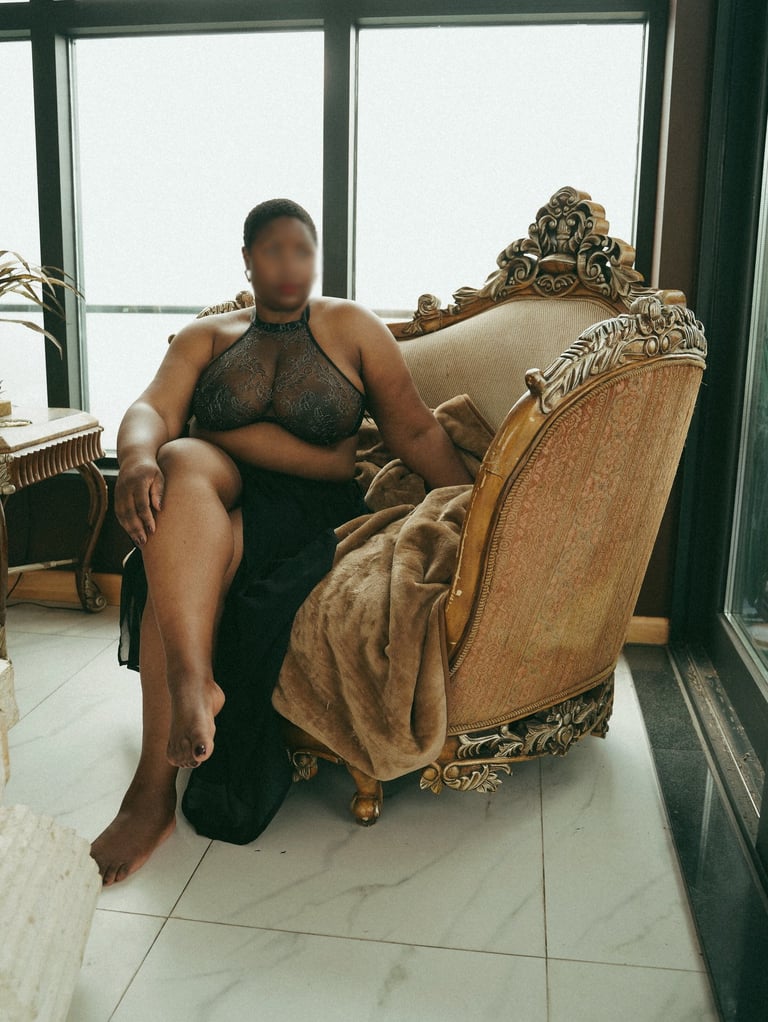 Teal Revel, London Escort, barefoot sitting on a chair