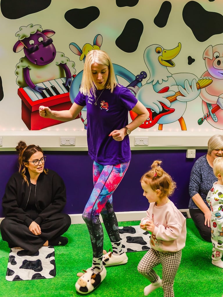 Action shot of Farmer Becca in the Moo Room dancing with a child.