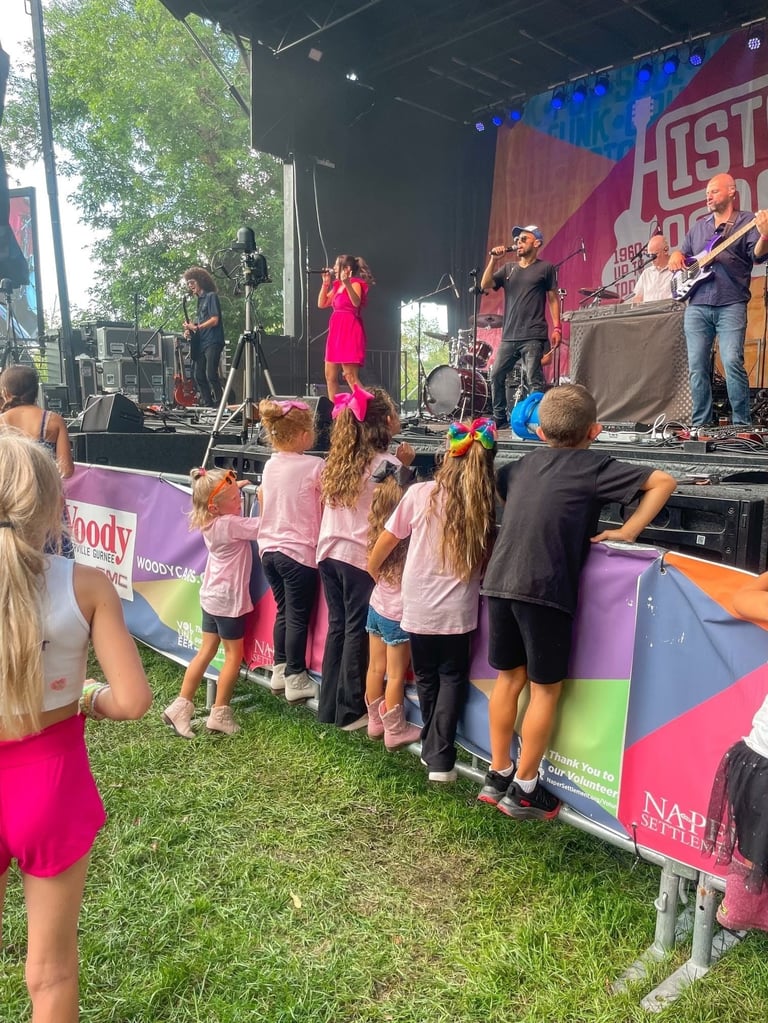 LuxeBand performing at an outdoor festival for an audience of children