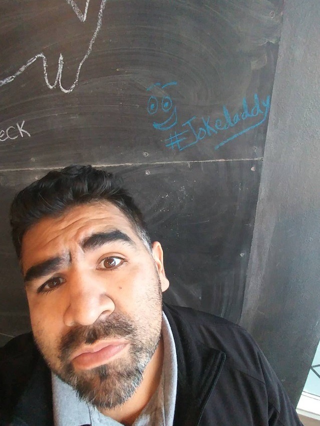Joke Daddy standing in front of a chalkboard