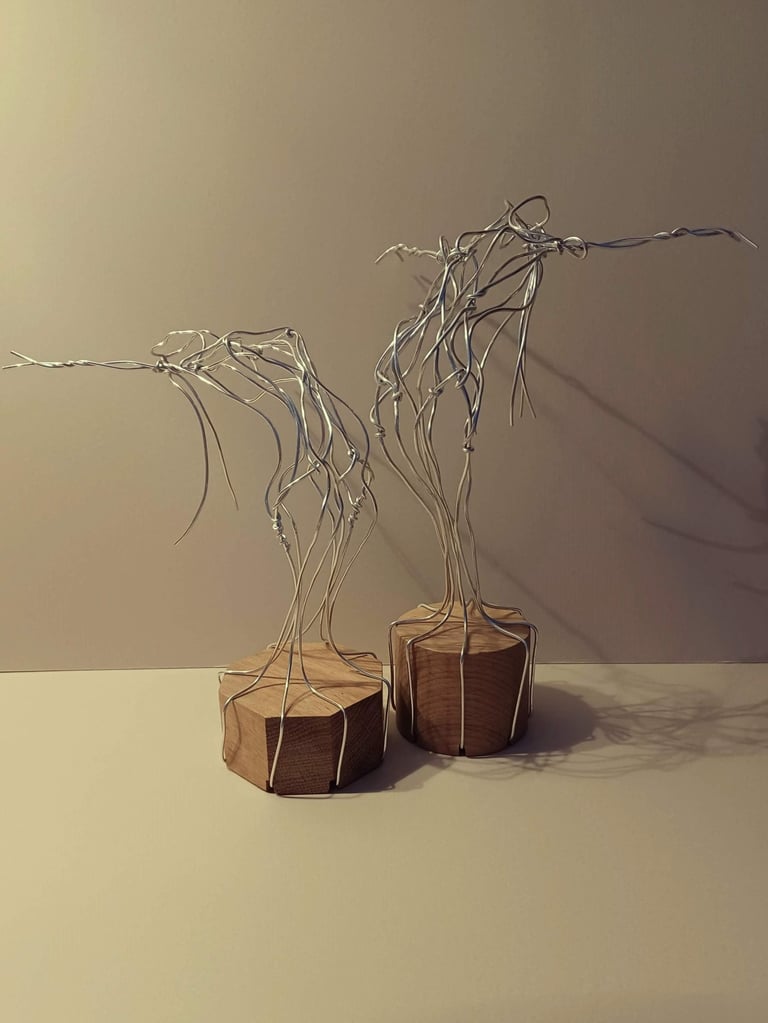 Two similar wire sculptures of complete female figures, standing, bending over backwards, arms out