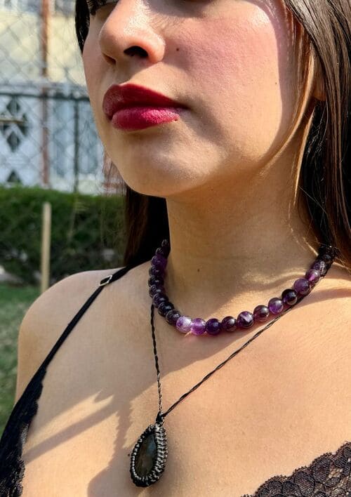 Mujer usando collares hechos con minerales en macramé