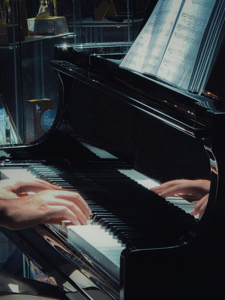Close-up of a pianist's hands playing a black grand piano with sheet music in a dimly lit setting.