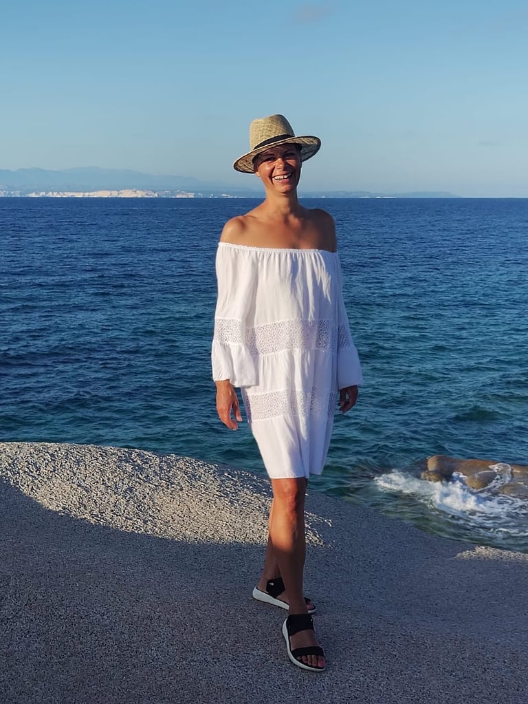 Stephanie Kabelin am Strand mit Hut und weißem Kleid