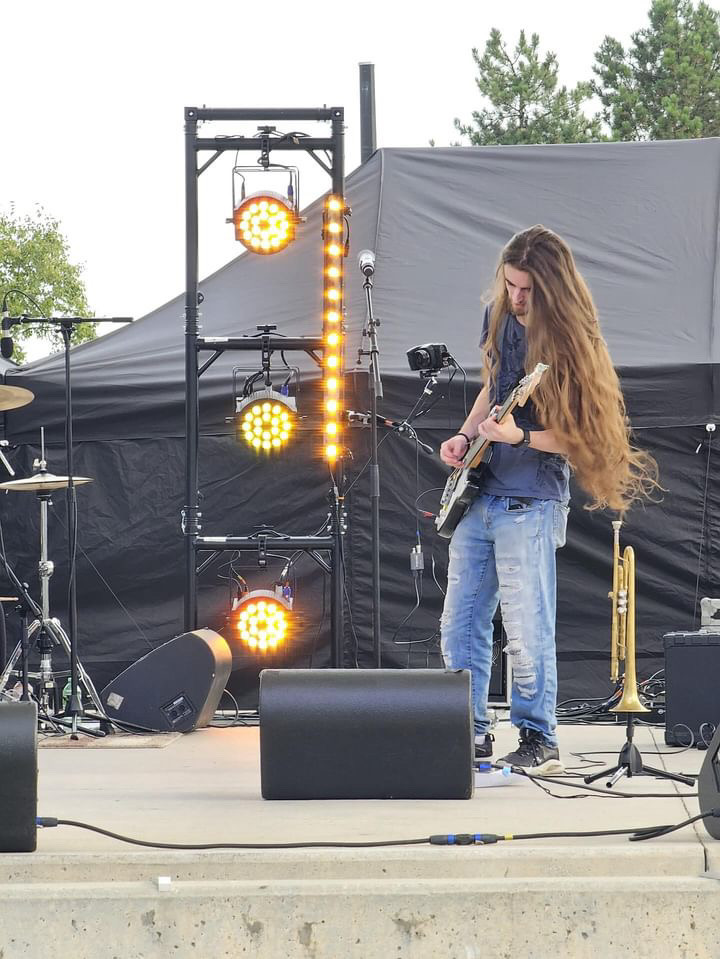 Camus playing bass at a live outdoor show
