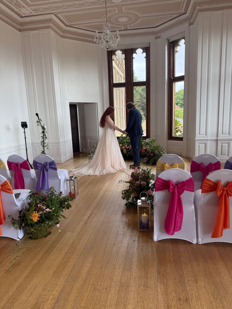 a bride and groom are standing in a room with white chairs
