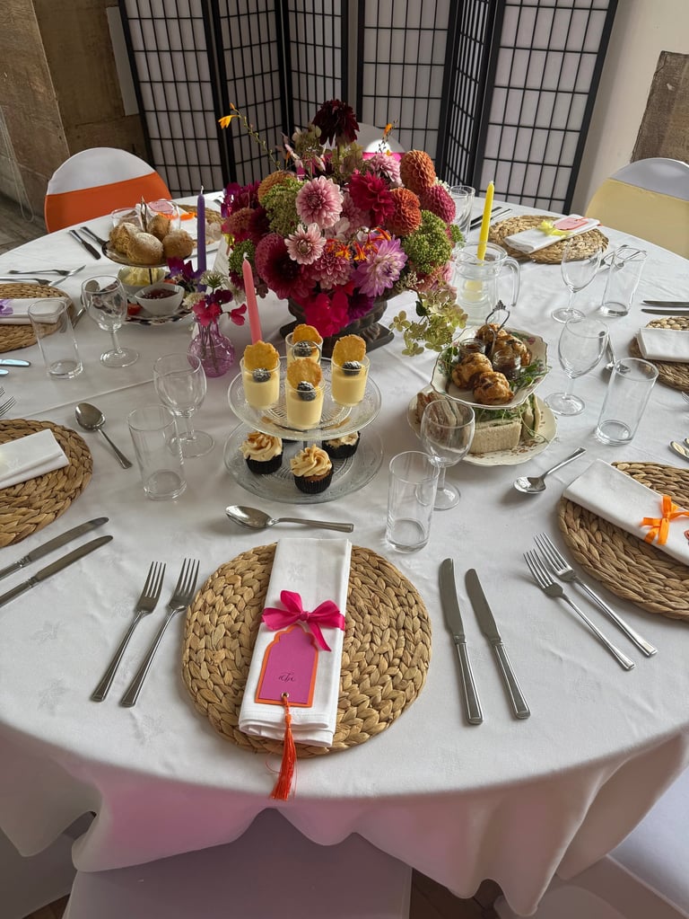 a wedding breakfast table with afternoon tea and flowers