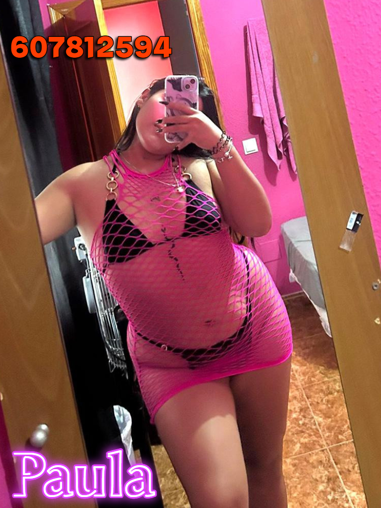 a woman in a pink dress is taking a selfie