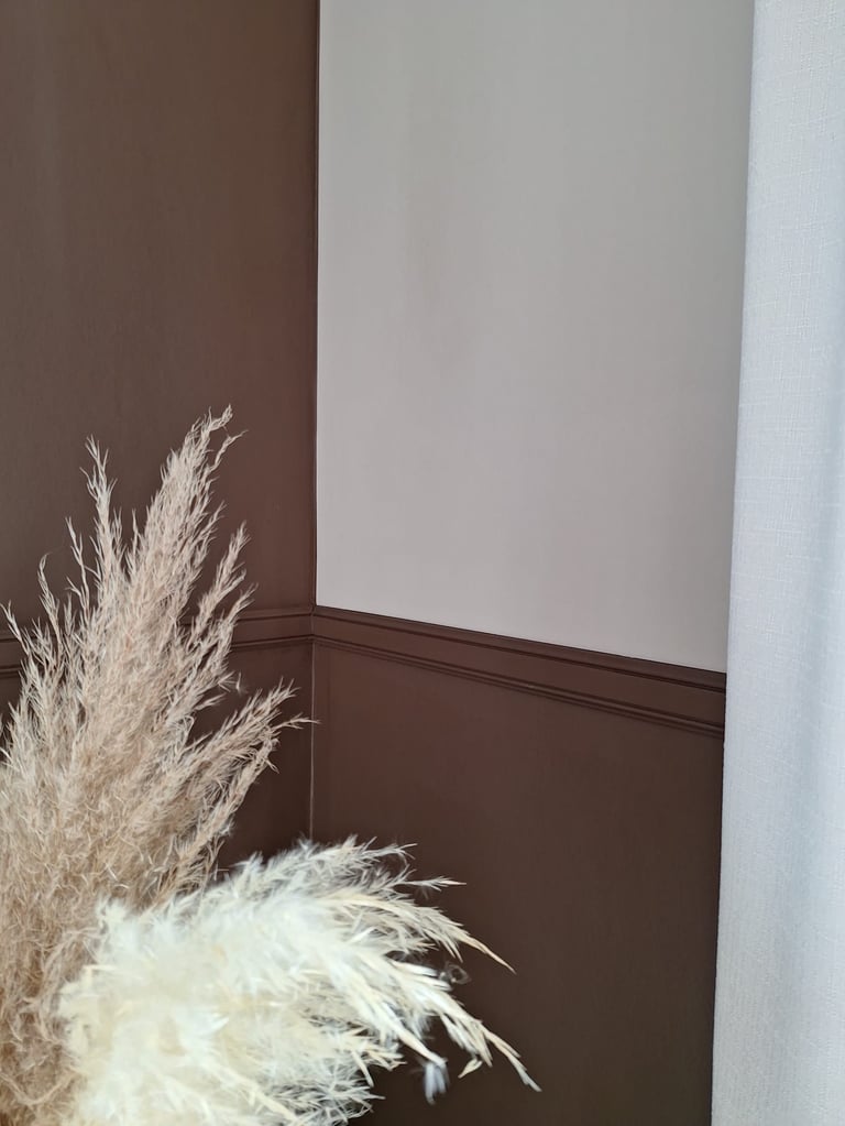 Zoom sur un coin de mur beige et brun avec des fleurs séchées pampas