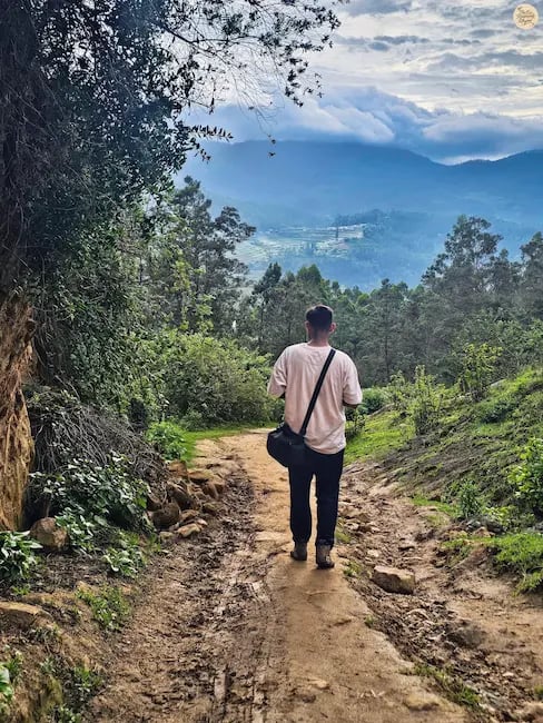 Trekking the muddy trail to Poondi Lake, surrounded by lush greenery and rolling hills.