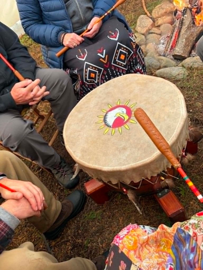 Personnes autour d'un gros tambour traditionnel au sol. 