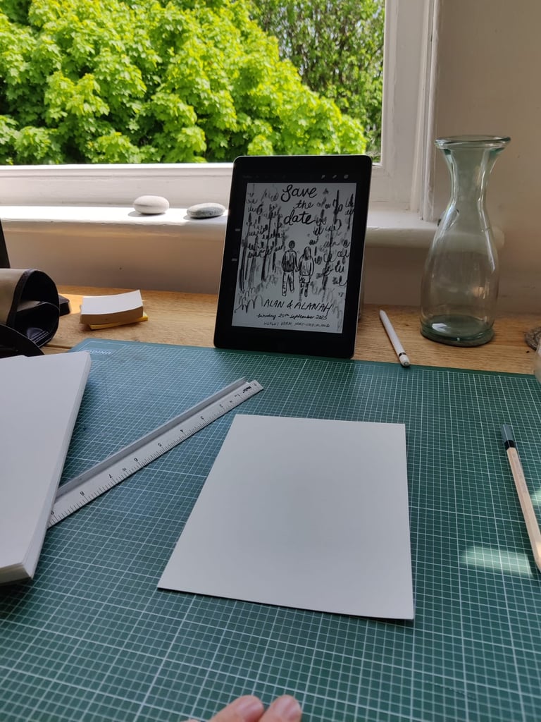 Eleanor's (elsillustrations) hand holding a pen and a tablet with a sketch of the save the dates