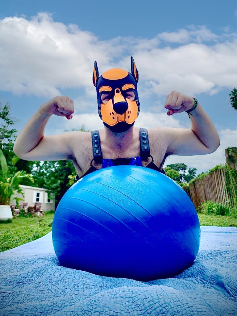 A man playing outside with a ball wearing a pup mask and gear.