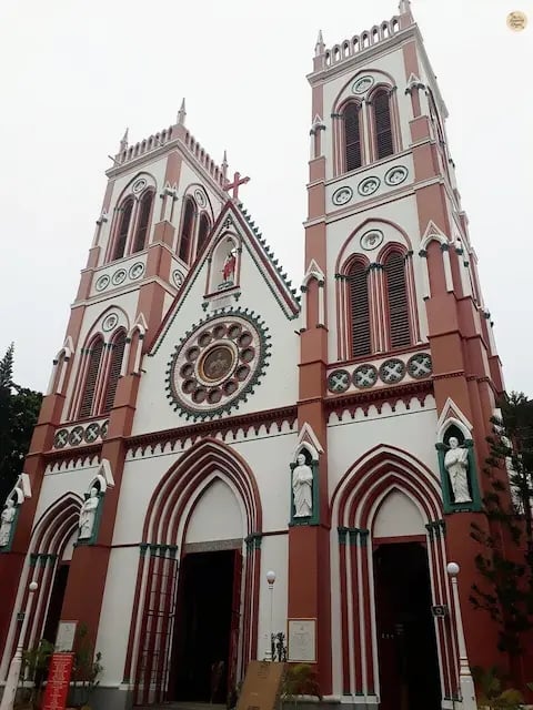 Exterior of the Sacred Heart Basilica in Pondicherry with red-and-white Gothic design.