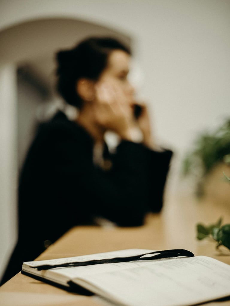 a woman in a black suit and a notebook with a pen and a pen