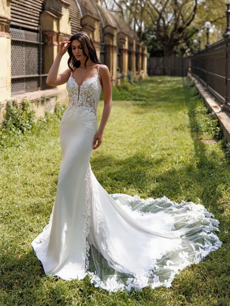 a woman in a white dress standing in the grass