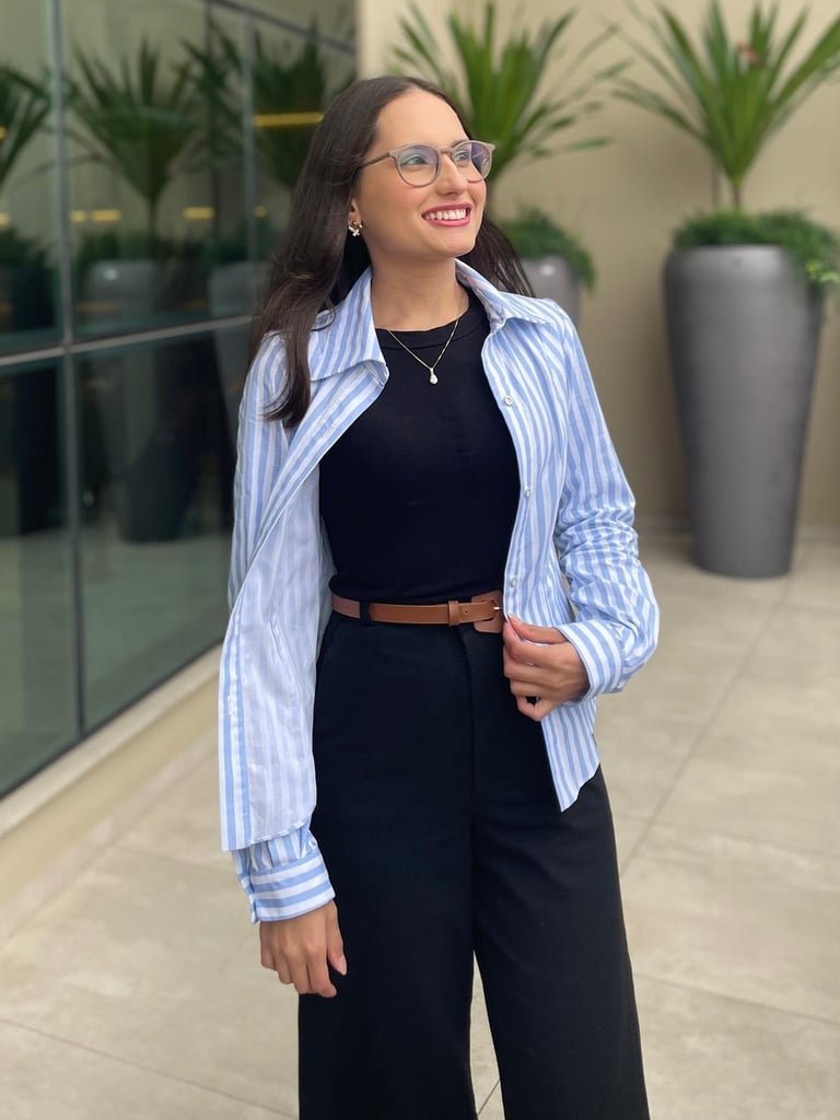 Mulher em pé usando uma camisa slim listrada 