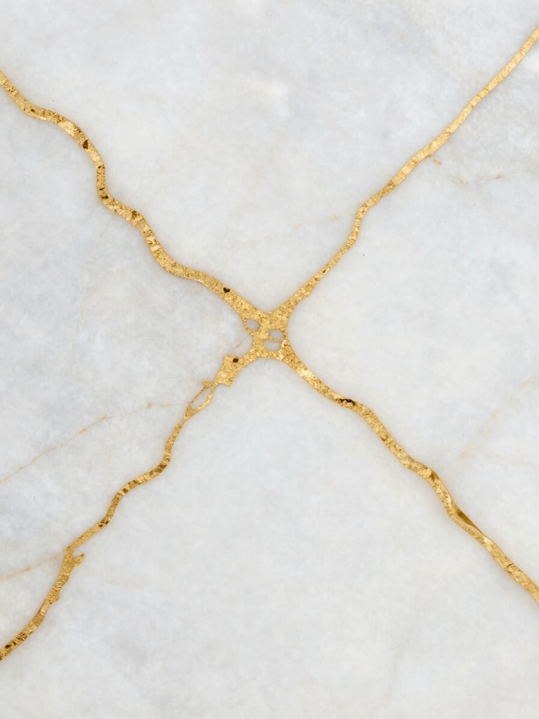 Extreme close-up of polished white alabaster marble with natural gold veins, soft shadows, luxury architectural texture