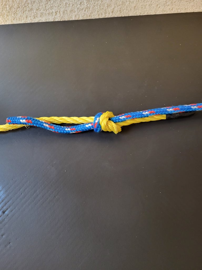 Tightened fisherman's knot joining yellow poly-line and blue climbing ropes