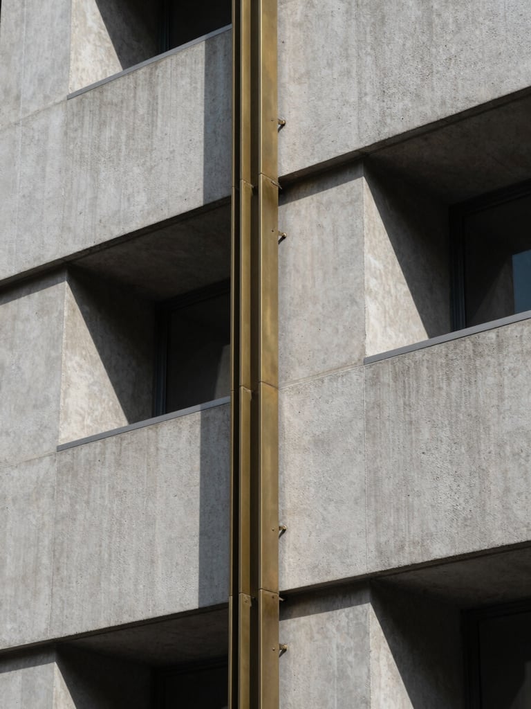 Extreme macro detail of a modern architectural facade, sharp shadows, cool daylight, concrete and brass elements.
