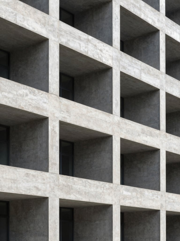 Structured architectural concrete facade of a modern research institution, sharp linear shadows, cool daylight, high contrast