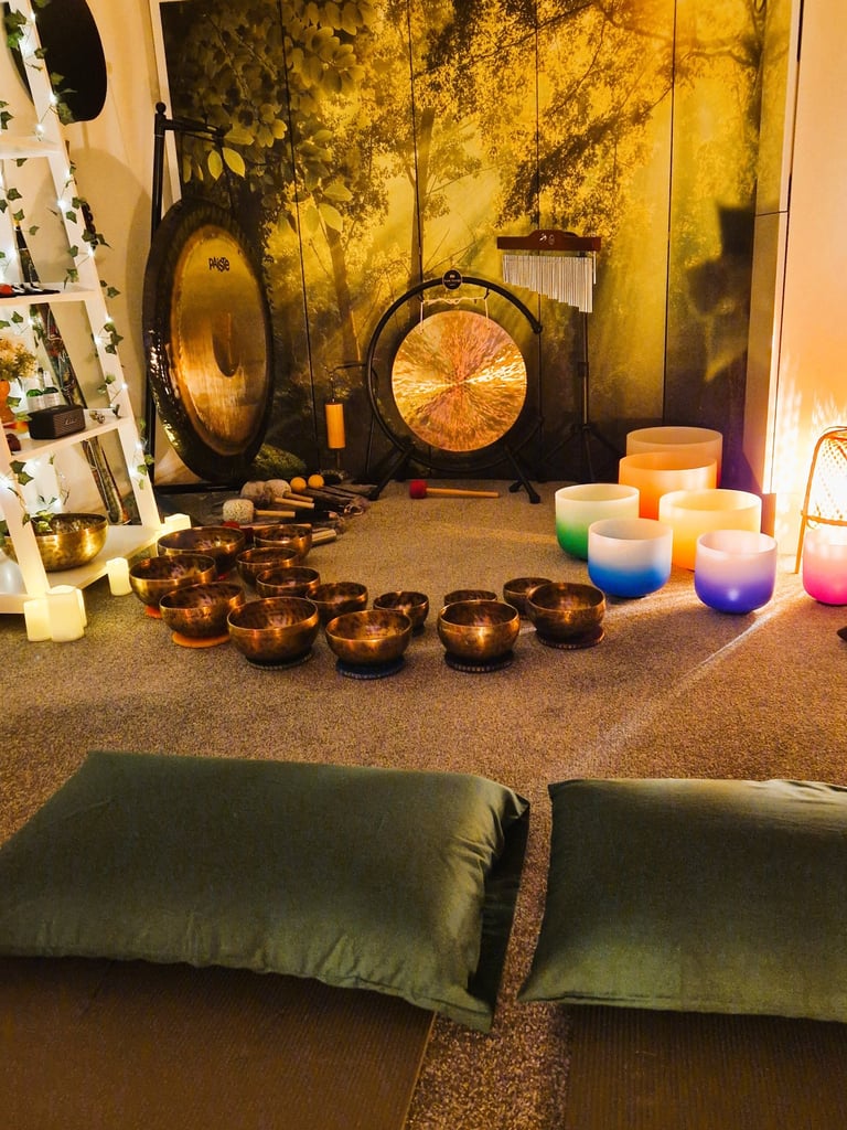 Studio with gongs and singing bowls on the floor in front of two pillows