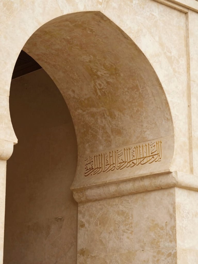 Close-up of elegant classical Arabic calligraphy engraved on a warm stone archway, soft ambient light, architectural detail, no people.