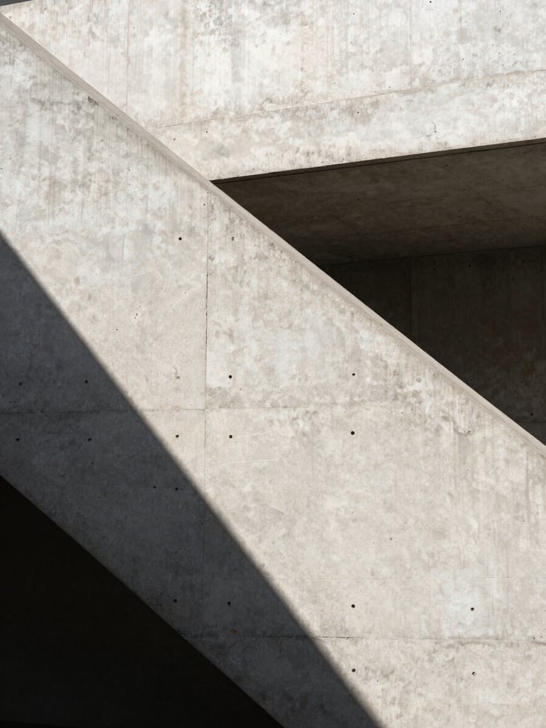 Abstract architectural concrete staircase with sharp shadows and clean structural lines, natural daylight, minimalist composition.