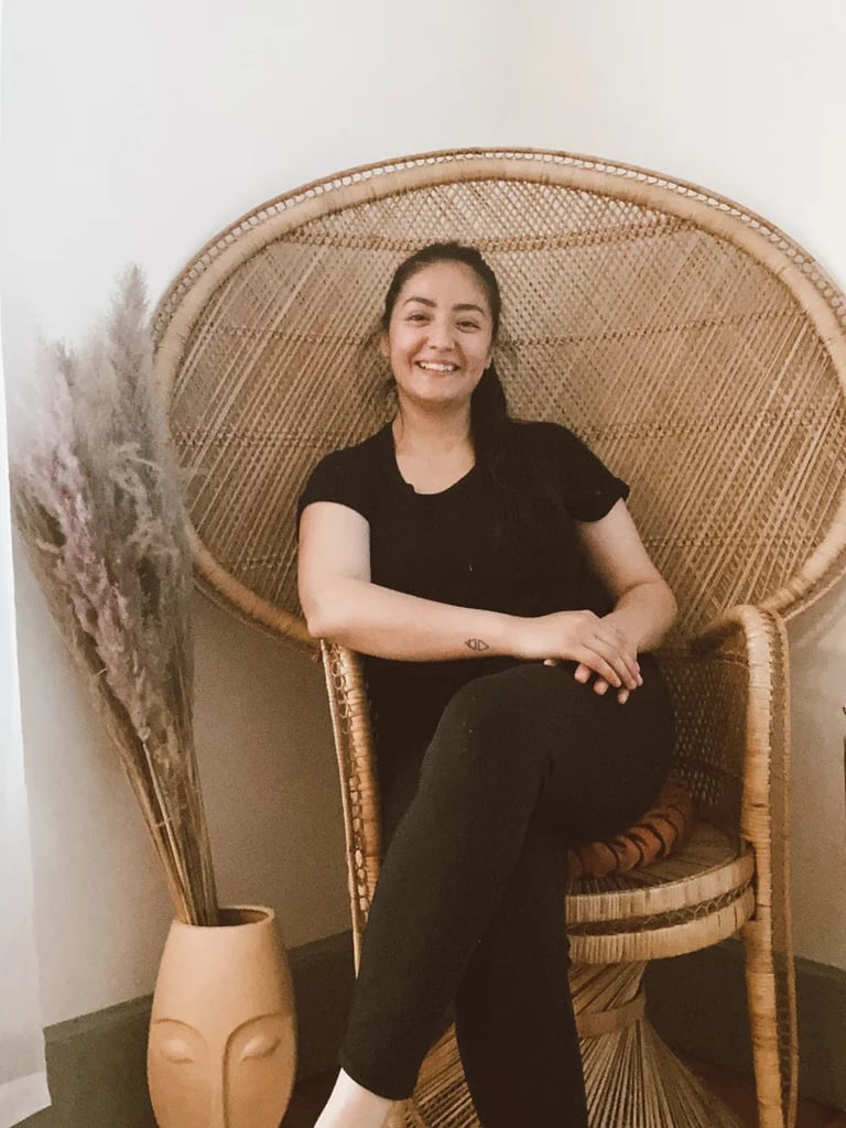 Smiling woman sitting in a wicker chair.