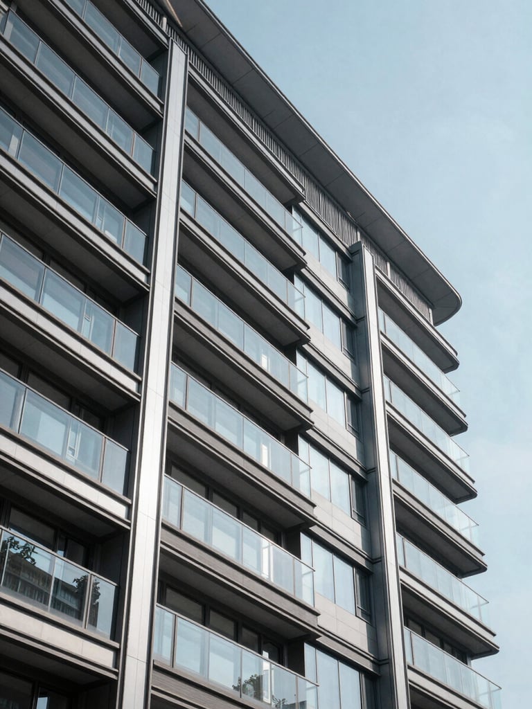 Crisp, high-contrast daylight shot of a modern real estate development facade, steel and glass structure reflecting clear sky.