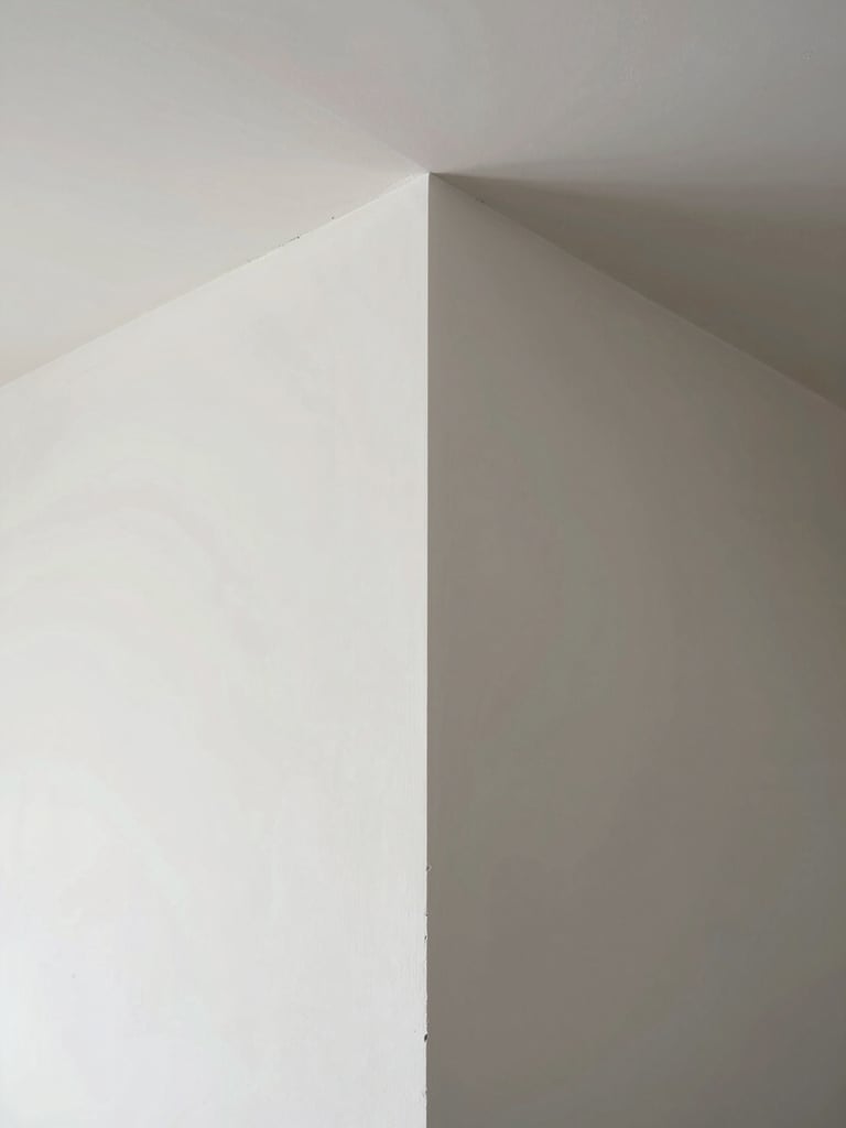 Straight-on geometric perspective of a perfectly finished drywall corner, crisp white paint, natural daylight casting clean shadows, architectural precision.