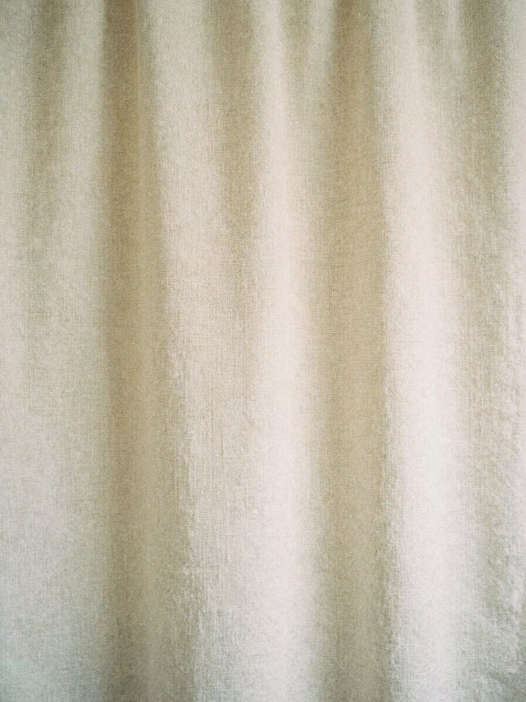 Minimalist close-up of soft beige linen texture, warm overcast daylight, gentle shadows, elegant Japandi aesthetic, 35mm film