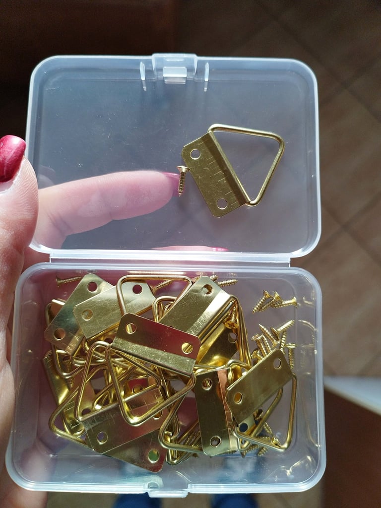 Set of 20 golden two-hole triangular picture hooks with mounting screws for hanging framed artwork 