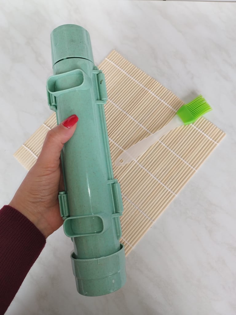 Green sushi making kit with bamboo rolling mat, sushi bazooka, and oil brush for creating sushi