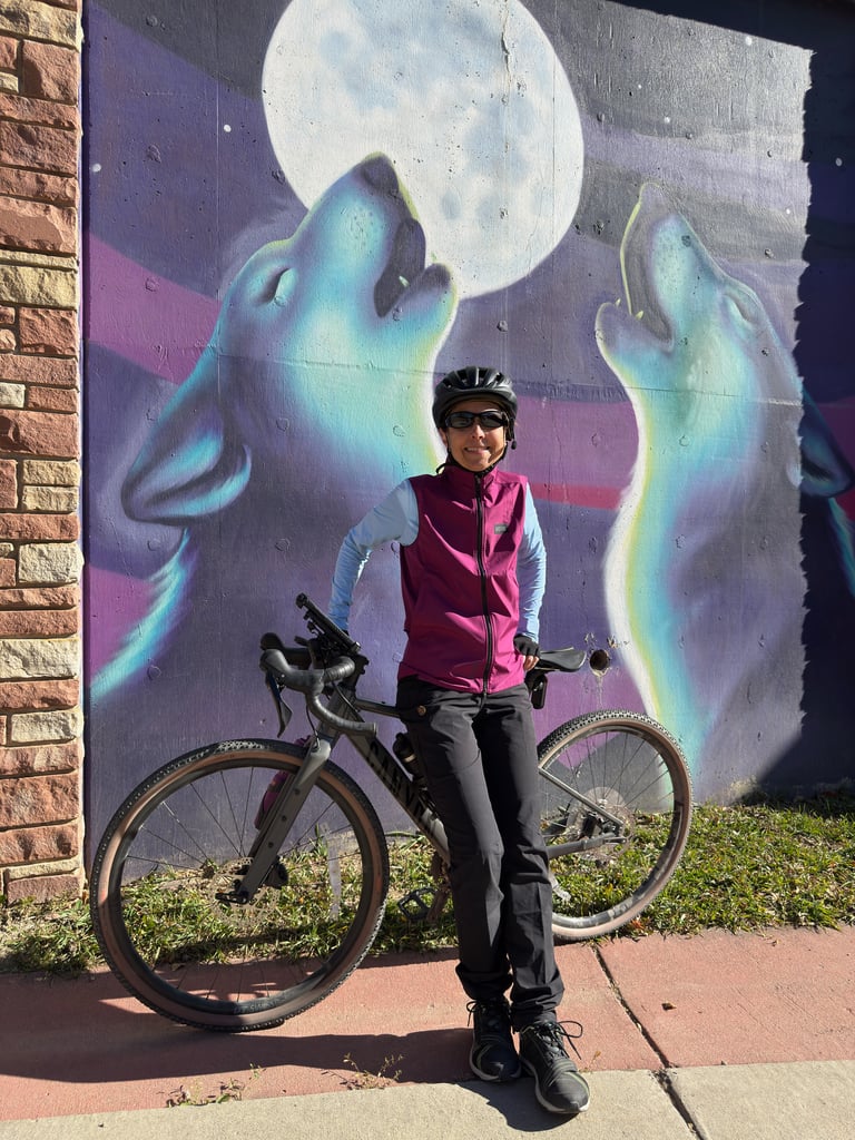 The author posing with her Canyon bike in front of a wolf mural
