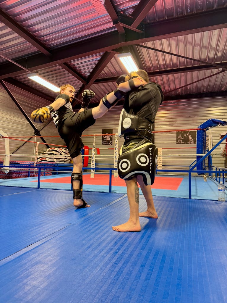 Entraînement de boxe : un boxeur en pleine frappe sur une patte d’ours tenue par son coach